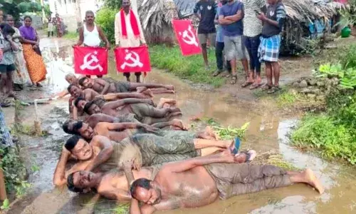 ரோட்டில் தேங்கியுள்ள மழைநீரில் உருளுதண்டம் போட்டு நூதன போராட்டம்