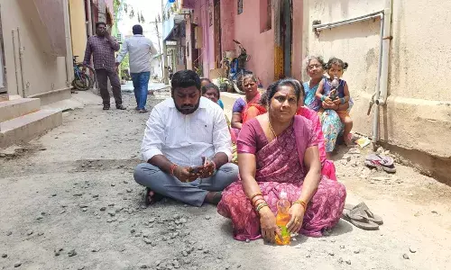 தரமற்ற சாலைப் பணி!  பெட்ரோல் கேனுடன் சாலையில் அமர்ந்த கவுன்சிலர்